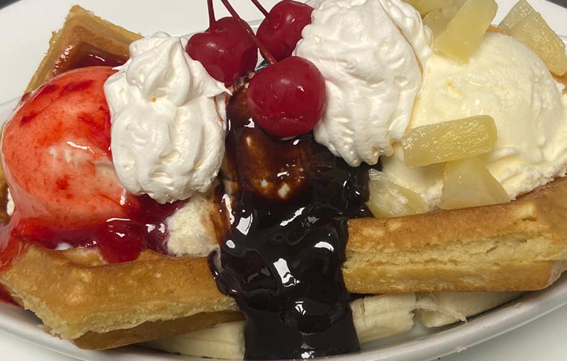 waffle-with-cream-accompanied-with-cherry-and-chocolate-sauce waffle with cream accompanied with cherry and chocolate sauce